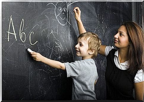 Maestra-con-niño-en-la-pizarra-dibujando