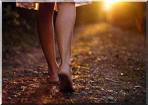 A woman walking barefoot representing moving forward